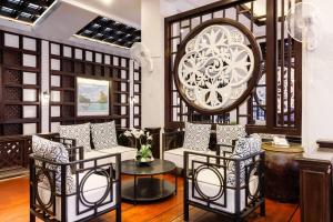 a lobby with chairs and a large clock on the wall at Days Inn by Wyndham Patong Beach in Patong Beach +156 photos