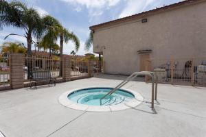 a small pool with a water slide in a yard at Days Inn & Suites by Wyndham South Gate in South Gate