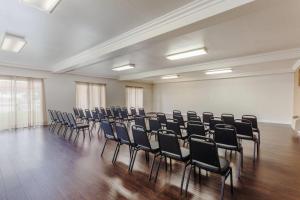 an empty room with chairs in a room with wood floors at Days Inn & Suites by Wyndham South Gate in South Gate