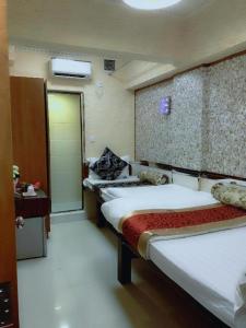 a hotel room with three beds and a door at New Fortunate Guest House in Hong Kong