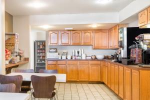 a kitchen with wooden cabinets and a table and chairs at Super 8 by Wyndham Jasper in Jasper