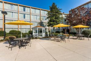 a courtyard with tables and chairs and umbrellas at Wyndham Garden Greensboro in Greensboro