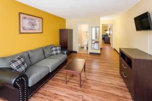a living room with a couch and a tv at Days Inn by Wyndham Madison in Madison