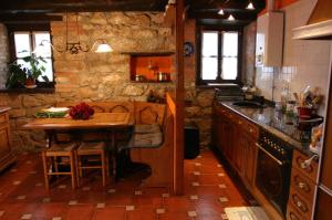 a kitchen with a table and a stone wall at El Trebano in Cardes