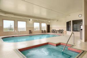 a large swimming pool in a building at Days Inn by Wyndham Innisfail in Innisfail