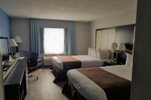 a hotel room with two beds and a window at Wyndham Garden Hotel - Jacksonville in Jacksonville