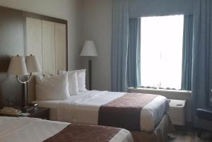 a hotel room with two beds and a window at Wyndham Garden Hotel - Jacksonville in Jacksonville +9 photos