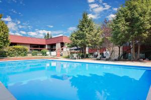 a large blue swimming pool in front of a building at Ramada by Wyndham Pinewood Park Resort North Bay in North Bay