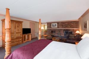 a bedroom with a bed and a living room at Ramada by Wyndham Pinewood Park Resort North Bay in North Bay