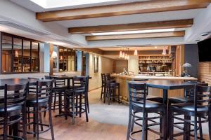 a bar with black bar stools in a restaurant at Ramada by Wyndham Pinewood Park Resort North Bay in North Bay