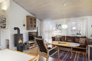 a living room with a table and a fireplace at 20723-Ulfborg-Sortebaervej-1 in Ulfborg