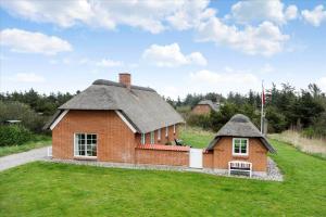 a small house with a thatched roof on a field at 20723-Ulfborg-Sortebaervej-1 in Ulfborg