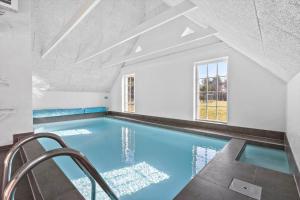 an indoor swimming pool with blue water in a house at 51401-Ulfborg-Sdr-Fjandvej-46 in Ulfborg