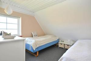 a small bedroom with a bed and a window at 20202-Ulfborg-Husby-Klitvej-15 in Ulfborg