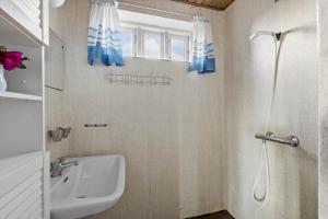 a bathroom with a sink and a shower with blue curtains at 20202-Ulfborg-Husby-Klitvej-15 in Ulfborg +27 photos