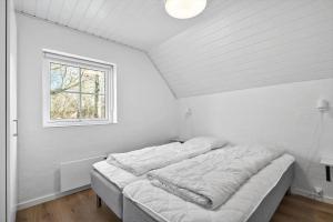 a white room with two beds in it with a window at 51401-Ulfborg-Sdr-Fjandvej-46 in Ulfborg +32 photos
