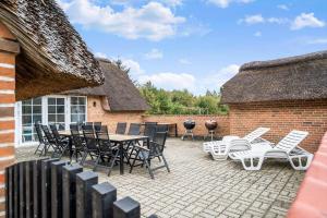 a patio with a table and chairs and a brick building at 51401-Ulfborg-Sdr-Fjandvej-46 in Ulfborg