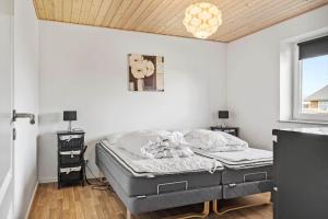 a bedroom with a bed in the corner of a room at 70751-Ulfborg-Fjordvaenget-13 in Ulfborg