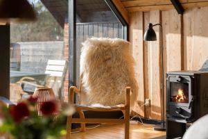 a furry animal sitting in a chair next to a fireplace at 20039-Ulfborg-Sortebaervej-8 in Ulfborg
