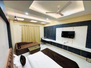 a living room with a couch and a flat screen tv at Hotel Sunny Jhalawar in Jhālāwār