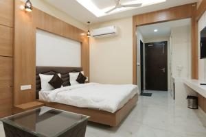 a bedroom with a bed and a table in it at Hotel Sunny Jhalawar in Jhālāwār
