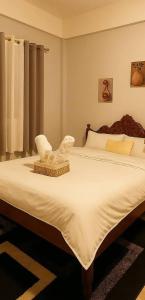 a bedroom with a large bed with a chair on it at Perrera Guesthouse in Santa Ana