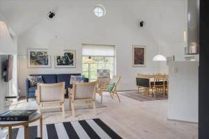 a living room with chairs and a dining room at 20780-Ulfborg-Sundhuse-26 in Ulfborg