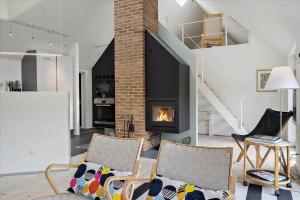 a living room with two chairs and a fireplace at 20780-Ulfborg-Sundhuse-26 in Ulfborg
