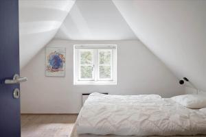 a white bedroom with a bed and a window at 20780-Ulfborg-Sundhuse-26 in Ulfborg
