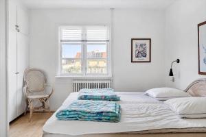 a white bedroom with two beds and a window at 70268-Ulfborg-Vesterhavsgade-16 in Ulfborg