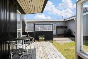a patio with two chairs and a table on a deck at 70268-Ulfborg-Vesterhavsgade-16 in Ulfborg +13 photos
