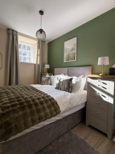 a bedroom with a large bed with green walls at Townhouse in Shaftesbury