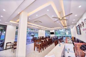 a restaurant with tables and chairs and a ceiling fan at Tuấn Đạt Luxury FLC Sầm Sơn in Sầm Sơn
