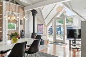 a dining room with a table and chairs and a tv at 30071-Ulfborg-Klovervej-479 in Ulfborg
