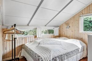 a bedroom with a bed in a room with wooden walls at 30071-Ulfborg-Klovervej-479 in Ulfborg
