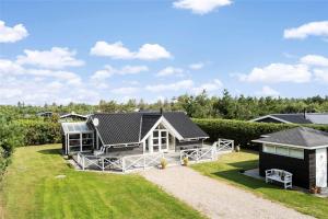 a small house on a lawn with a house at 30071-Ulfborg-Klovervej-479 in Ulfborg