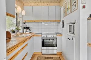 a kitchen with white cabinets and a stove top oven at 20145-Ulfborg-Knakvej-16 in Ulfborg +17 photos