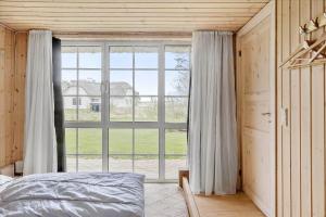 a bedroom with a bed and a large window at 20145-Ulfborg-Knakvej-16 in Ulfborg