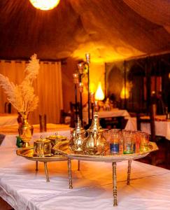 a table with a tray with glasses on it at Aladdin merzouga camp in Merzouga