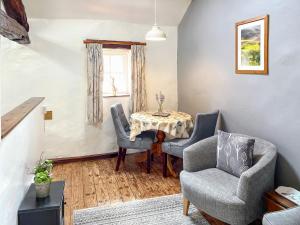 a living room with a table and chairs and a window at Rebecca Puddle Duck Cottage in Bassenthwaite