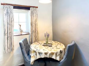 a table with a vase on it in a room at Rebecca Puddle Duck Cottage in Bassenthwaite