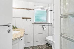 a white bathroom with a toilet and a window at 80608-Vemb-Knudehus-51 in Vemb +20 photos