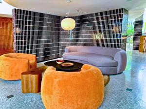 a living room with orange chairs and a blue couch at Silom Serene A Boutique Hotel in Bangkok