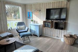 a living room with a television and a chair at 30826-Ulfborg-Klovervej-480 in Ulfborg