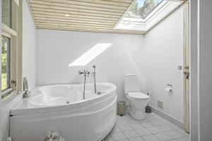 a bathroom with a tub and a toilet with a skylight at 30826-Ulfborg-Klovervej-480 in Ulfborg +16 photos