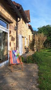 a colorful chair sitting outside of a house at Maison la Bambine chambre nature in Ozolles
