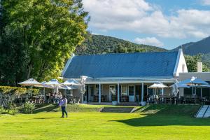 a person standing in the grass in front of a building at Vogelsang Farm Cottage in Oudtshoorn
