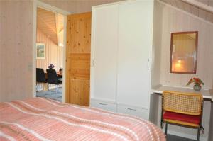 a bedroom with a bed and a cabinet and a table at 30070-Ulfborg-Klovervej-478 in Ulfborg