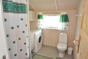 a small bathroom with a toilet and a washing machine at 30070-Ulfborg-Klovervej-478 in Ulfborg +13 photos