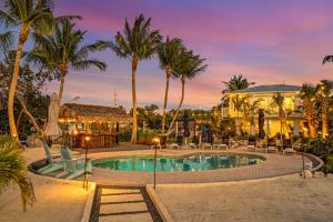 a resort pool with palm trees and a building at Peninsula Villa Boat Dock Heated Pool Sunset Point in Islamorada
